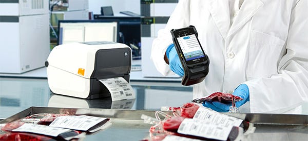 Pflegepersonal, das mithilfe eines RFID-Scanners und RFID-Druckers Blutbeuteletiketten erstellt und scannt