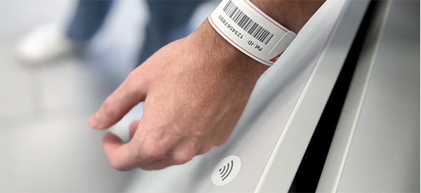 RFID-Patientenarmband Anwendungsfoto eines Armbandes mit RFID-Technik: Jemand öffnet mit dem Armband einen Schrank mit RFID-Chip