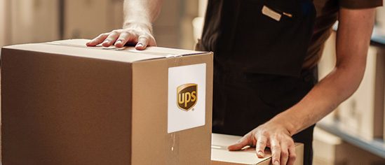 Paket mit UPS-Versandetikett in einem Versandlager.